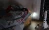 A child sleeping in bed next to a night light and a toy rocket. Anteprima dell’immagine prodotto