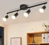 A black ceiling light fixture with four adjustable spotlights is mounted on a white ceiling. Produktbild-Vorschau