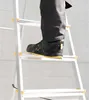 A person's foot wearing a black safety shoe is stepping on a rung of a silver ladder. Anteprima dell’immagine prodotto