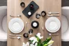 A beautifully set dining table with white plates, cutlery, glasses, and a candle. Produktbild-Vorschau