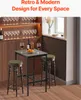 A small bar table with two stools in a room with a wine rack and a window. Produktbild-Vorschau