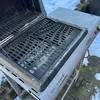 A close-up view of a gas grill with its lid open, showing the grates. Snow is visible on the ground around the grill. Náhľad obrázku produktu