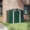 A green metal garden shed is shown in a backyard setting, next to a brick house. Podgląd zdjęcia produktu