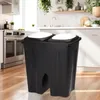 A black dual trash can with white lids sits on a wooden floor in a kitchen. Anteprima dell’immagine prodotto
