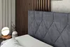 A close-up view of a dark gray upholstered headboard of a bed, with a white pillow in the foreground. In the background, there is a decorative wooden wall paneling and a white vase with a plant. Produktbild-Vorschau