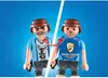 Two Playmobil figures are shown, one with a t-shirt and the other with a police vest, with arrows indicating a transformation or interchangeability. Produktbild-Vorschau