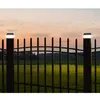 Two solar fence post lights are illuminated at dusk, mounted on a black metal fence. Produktbild-Vorschau