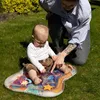 A baby is playing on an inflatable water mat on the grass, with an adult supervising. Náhľad obrázku produktu