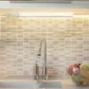 A close-up view of a kitchen sink area with a faucet, soap dispenser, and a bowl of fruit, illuminated by an LED under-cabinet light. Produktbild-Vorschau