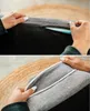Close-up of hands interacting with a gray dog bed, showing a zipper and piping detail. Náhled obrázku produktu