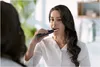 A woman brushing her teeth in front of a mirror. Anteprima dell’immagine prodotto
