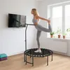 A woman is exercising on a mini trampoline in a room with a TV and a window. Produktbild-Vorschau