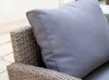 A close-up of a grey cushion on a rattan chair. Náhľad obrázku produktu