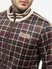 A close-up shot of a man wearing a plaid track jacket. Anteprima dell’immagine prodotto