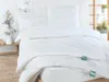 A neatly made bed with white bedding, including a duvet and pillows, in a bright room. Produktbild-Vorschau