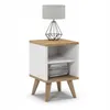A white and oak bedside table with a lamp on top and books on the shelf. Náhled obrázku produktu