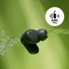 A close-up of a dark gray in-ear headphone with a green background and a white circle containing text and a symbol. Produktbild-Vorschau