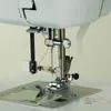 A close-up view of a sewing machine needle and thread. Produktbild-Vorschau