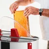A beekeeper is shown holding a honeycomb frame over a honey extractor. Produktbild-Vorschau