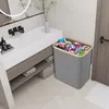 A laundry basket filled with clothes sits next to a bathroom vanity. Produktbild-Vorschau