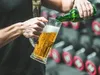 A person pouring beer into a mug in a gym setting. Produktbild-Vorschau