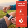 A person is shown applying a tourniquet to their leg outdoors. Produktbild-Vorschau