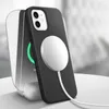 A black phone case with a white MagSafe charger attached is shown on a charging stand. Produktbild-Vorschau