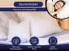 A woman is sleeping peacefully on a bed with several white pillows, suggesting comfort and quality sleep. Produktbild-Vorschau