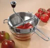 A food mill with tomatoes and apples on a wooden surface. Podgląd zdjęcia produktu