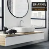 A mini heater placed on a bathroom vanity next to a sink and toiletries, with a large mirror and window in the background. Produktbild-Vorschau