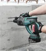 A person wearing gloves is using a Makita rotary hammer drill to drill into a concrete wall. Voir les images du produit