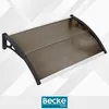 A product shot of a brown awning with black brackets, set against a light gray and white geometric background. Anteprima dell’immagine prodotto
