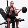 A man is using a weight bench to perform bicep curls with a barbell. Podgląd zdjęcia produktu