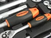 A close-up view of two ratchet handles from a tool set, with other tools visible in the background. Anteprima dell’immagine prodotto