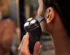 A person is using an electric shaver to trim their beard in front of a mirror. Podgląd zdjęcia produktu