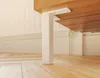 A close-up view of white furniture legs attached to a wooden surface, resting on a wooden floor. Produktbild-Vorschau