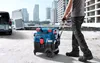 A person is pulling a blue and black Bosch wet/dry vacuum cleaner on wheels next to a white van. Anteprima dell’immagine prodotto