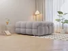 A modern living room with a gray tufted ottoman, a floor lamp, and a plant. Produktbild-Vorschau