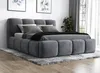 A modern upholstered bed with a headboard and footboard, set up in a bedroom with a rug and artwork on the wall. Produktbild-Vorschau