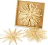 Three straw star ornaments are displayed on a white background, with one larger ornament inside a cardboard box. Produktbild-Vorschau