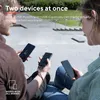 Two people sitting outside, charging their phones with a power bank. Produktbild-Vorschau