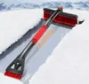 A snow brush and ice scraper is shown on a car windshield covered in snow and ice, with snowy mountains in the background. Anteprima dell’immagine prodotto