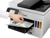 A hand is shown inserting a document into a Canon MAXIFY GX 7050 Multifunction Printer. Produktbild-Vorschau