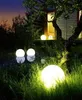 Outdoor garden scene at dusk with illuminated spherical lights. Anteprima dell’immagine prodotto