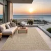 A balcony overlooking the ocean at sunset, furnished with a sofa, coffee table, and rug. Náhled obrázku produktu