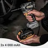 A person is holding a cordless impact wrench and a battery pack next to a car wheel. Produktbild-Vorschau