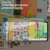 A smartphone screen displaying artwork, with a colorful building facade in the background. Podgląd zdjęcia produktu