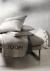 A stack of pillows and a blanket on a chaise lounge. Produktbild-Vorschau