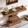 A wooden console table with a modern, stacked design is shown against a white wall, with a painting above it and a vase of flowers and a magazine on top. Dimensions are indicated by yellow lines and text. Anteprima dell’immagine prodotto