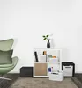 A modern living room scene with a green armchair, a white shelving unit with storage boxes, and a black storage cube. Voir les images du produit